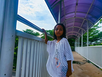 Portrait of young woman standing against wall