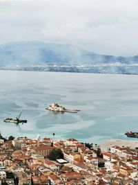 High angle view of townscape by sea against sky