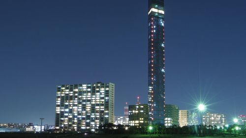 Illuminated buildings against sky at night