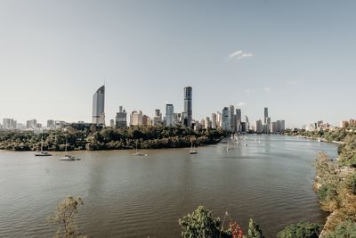 Scenic view of river by buildings against sky