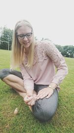 Smiling woman applying nail polish on toenails at park