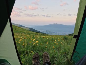 Low section of man on field against sky