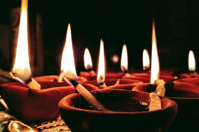 Close-up of burning diya in darkroom