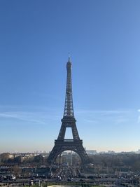 Communications tower in city against sky