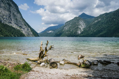 Scenic view of lake by mountains against sky