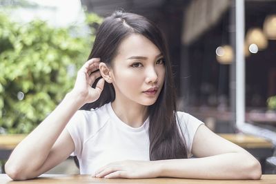 Portrait of young woman using mobile phone in city