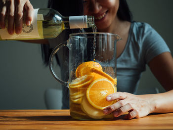 Smiling woman preparing drink