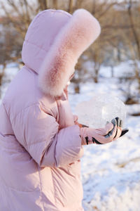 Rear view of woman standing on snow covered field