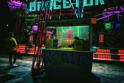 People at illuminated market stall