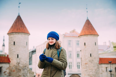 Full length of woman standing against building during winter