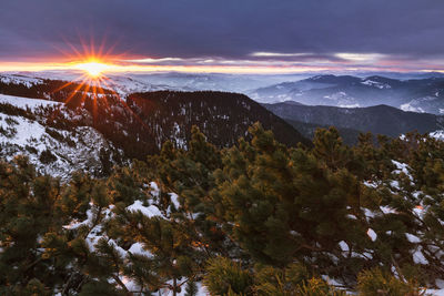 Scenic view of snowcapped mountains against sky at sunset