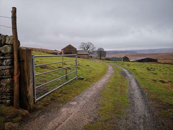 Road amidst field against sky