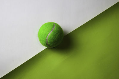 Directly above shot of tennis ball over two tone background