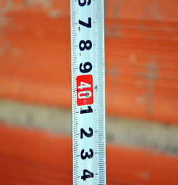 High angle close up of measuring tape against brick wall