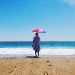 Rear view of woman standing on beach