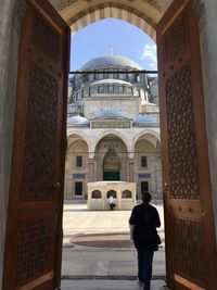 Rear view of man standing at entrance of building