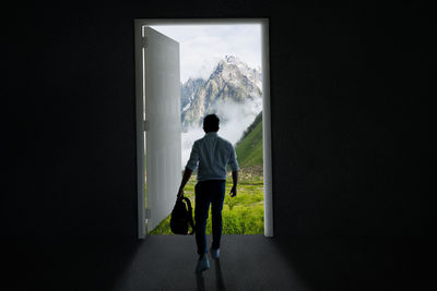 Rear view of man standing against wall