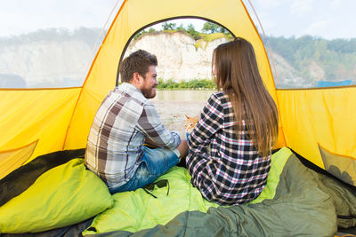 Rear view of couple sitting at tent