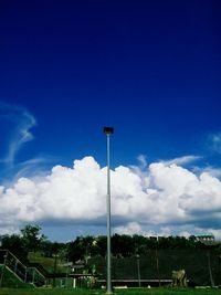 Low angle view of street lights against blue sky