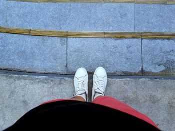 Low section of man standing on tiled floor