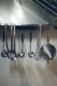 Utensils hanging against wall in kitchen at home