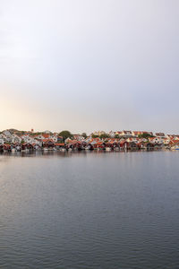 Sea by townscape against sky