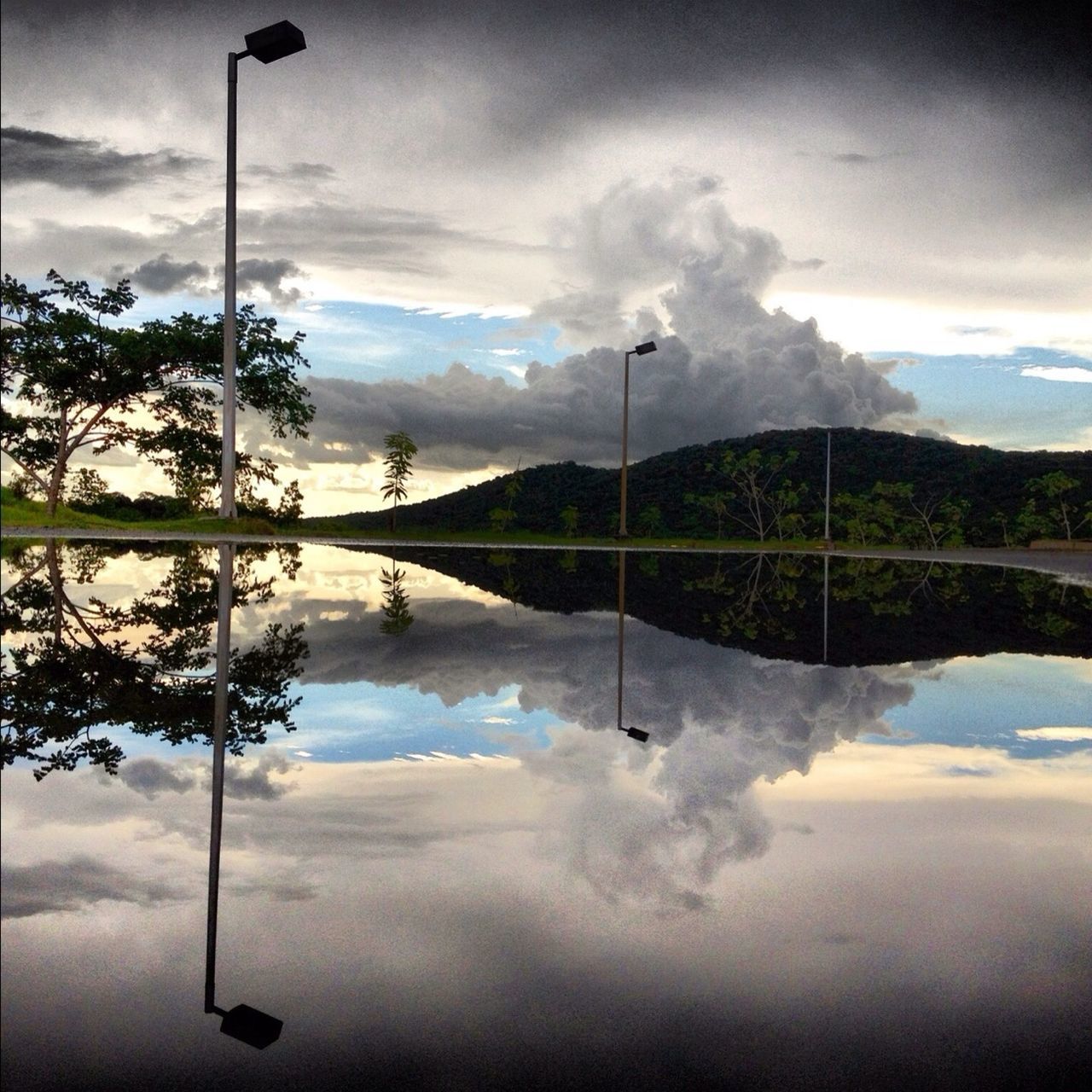 sky, tranquility, cloud - sky, reflection, tranquil scene, water, scenics, tree, street light, lake, beauty in nature, cloud, nature, cloudy, idyllic, mountain, outdoors, calm, pole, standing water