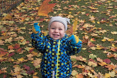 Portrait of smiling boy with autumn leaves