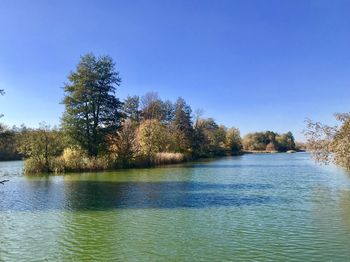 Scenic view of lake against clear blue sky