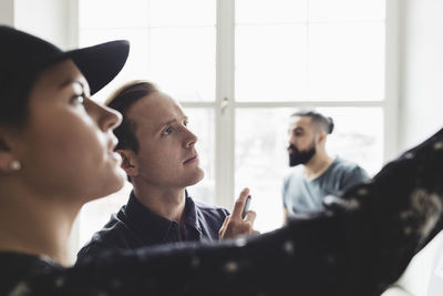 Engineers looking at whiteboard with male coworker in background