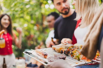 Midsection of people holding food outdoors
