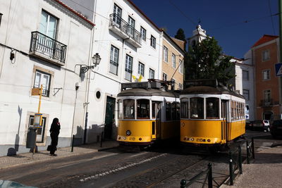 Trams on street by buildings in city
