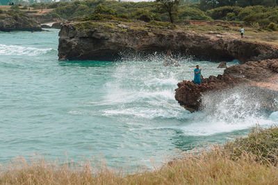 People on rocks by sea