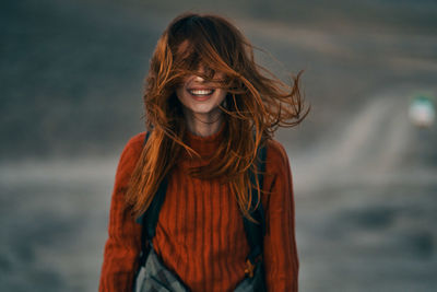 Portrait of smiling woman standing against sea