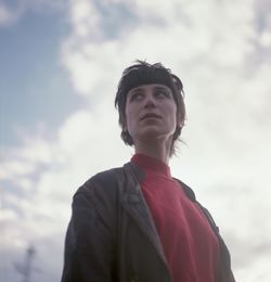 Low angle portrait of man standing against sky