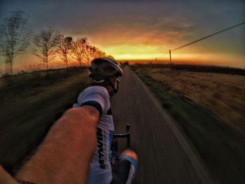 Man riding bicycle on road against sky