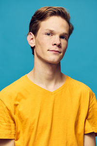 Portrait of young man against blue background