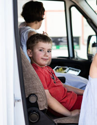 Portrait of boy traveling with mother in car