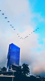 Low angle view of birds flying against sky