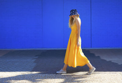 Woman standing against blue wall