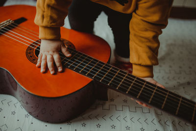 Midsection of child playing guitar