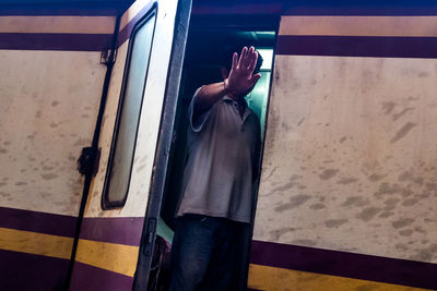 Midsection of man standing by window