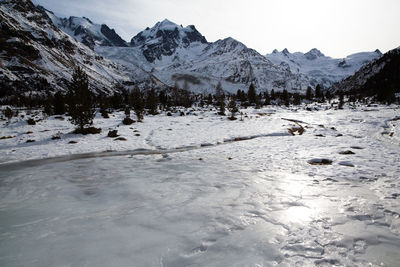 Scenic view of frozen mountains against sky