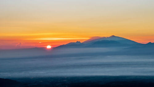 Scenic view of silhouette mountains against sky during sunset