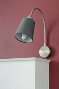 Close-up of electric lamp hanging on wall