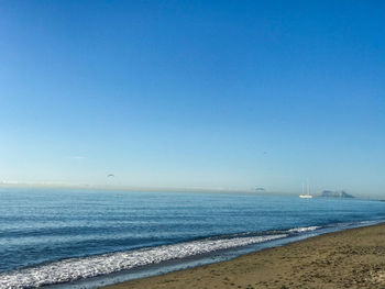 Scenic view of sea against clear blue sky