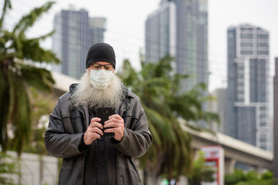 Portrait of man standing in city