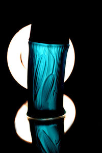 Close-up of illuminated lamp against black background