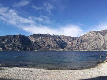 Scenic view of sea and mountains against blue sky