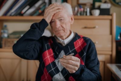 Midsection of man holding while sitting at home